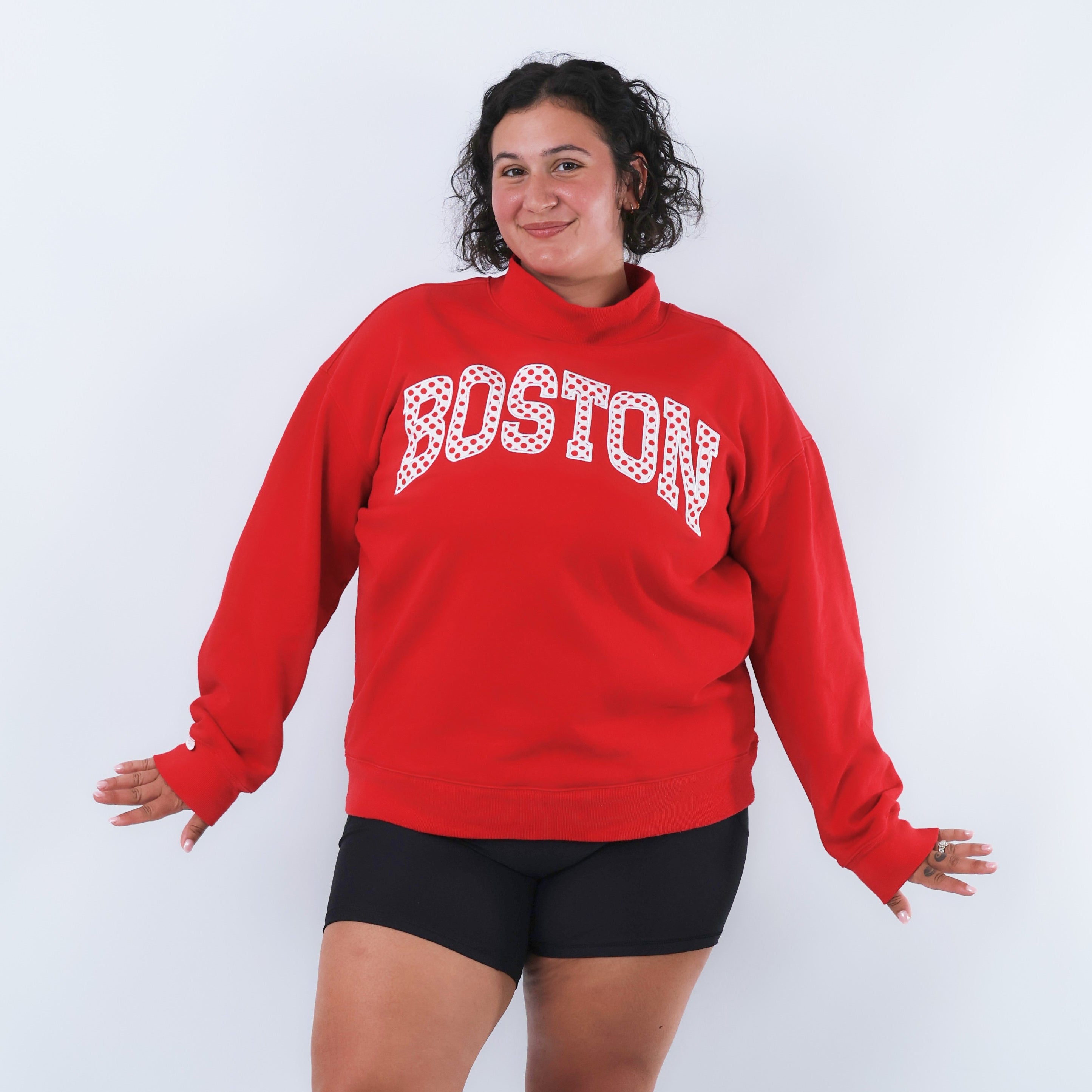 Person wearing a red 'Boston' sweatshirt on a white background